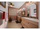The bathroom features double sinks, tile floors, natural wood cabinets, and updated lighting at 11860 Se 179Th St, Summerfield, FL 34491