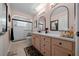 Spacious bathroom featuring double vanity, decorative mirrors, and walk-in shower at 11860 Se 179Th St, Summerfield, FL 34491