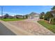 Beautifully paved driveway leading to a spacious three-car garage, complemented by lush landscaping at 11860 Se 179Th St, Summerfield, FL 34491