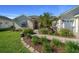 Charming single-story home with a well-manicured lawn, vibrant landscaping, and inviting red front door at 11860 Se 179Th St, Summerfield, FL 34491