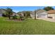 Well-maintained front yard with a lush lawn, palm trees, and neat landscaping enhancing the curb appeal of the home at 11860 Se 179Th St, Summerfield, FL 34491