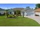 Charming two-story home with a well-manicured lawn, palm trees, and a brick-paved driveway leading to a two-car garage at 11860 Se 179Th St, Summerfield, FL 34491