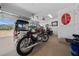 View of a spacious garage featuring a collection of motorcycles and a golf cart, complete with a polished floor at 11860 Se 179Th St, Summerfield, FL 34491
