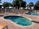 Inviting hot tub next to community pool with lounge chairs and well-maintained landscaping at 11860 Se 179Th St, Summerfield, FL 34491