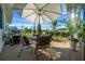 Covered patio area with outdoor seating, grill, and beautiful landscaping at 11860 Se 179Th St, Summerfield, FL 34491