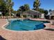 Sparkling community pool with brick surround, lounge chairs, and palm tree views at 11860 Se 179Th St, Summerfield, FL 34491
