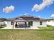 Backyard view showing a concrete patio, gazebo, grill and solar panels on the roof at 11995 Callicarpa Ln, Leesburg, FL 34788