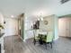 Open-concept living space featuring a dining area with stylish chairs and a view of the modern kitchen at 11995 Callicarpa Ln, Leesburg, FL 34788