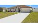 Well-maintained single-story home with a two-car garage, a clean driveway, and vibrant landscaping at 11995 Callicarpa Ln, Leesburg, FL 34788