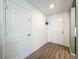 Welcoming foyer featuring stylish wood-look floors, a front door with glass panels, and crisp white walls at 11995 Callicarpa Ln, Leesburg, FL 34788