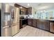 Modern kitchen featuring stainless steel appliances, dark wood cabinets and a tile floor at 11995 Callicarpa Ln, Leesburg, FL 34788