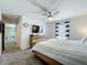 Bright main bedroom features a ceiling fan, natural light, and a large television, creating a cozy retreat at 11995 Callicarpa Ln, Leesburg, FL 34788