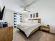 Comfortable main bedroom with a ceiling fan, natural light, and a wooden bed frame with a white duvet at 11995 Callicarpa Ln, Leesburg, FL 34788
