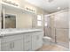 Bathroom featuring double sinks, shower, vanity, and tile floors at 12150 Se 88Th Ct, Belleview, FL 34420