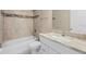 Bathroom featuring tiled walls, granite vanity, and a combination tub and shower at 12817 Sw 77Th Cir, Ocala, FL 34473