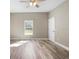 Bright bedroom featuring durable wood-look flooring, a ceiling fan and a window at 12817 Sw 77Th Cir, Ocala, FL 34473