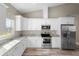 Modern kitchen features stainless steel appliances, granite countertops, and ample cabinet space at 12817 Sw 77Th Cir, Ocala, FL 34473