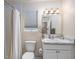 Bright bathroom featuring marble countertop, white cabinetry, and shower with neutral-toned curtain at 1282 Cottage Cir, Tavares, FL 32778