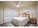 Bedroom features ceiling fan, nightstands, and white comforter on bed at 1282 Cottage Cir, Tavares, FL 32778