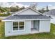 Side aerial view of home with light blue siding, gray roof, and green grass yard at 1282 Cottage Cir, Tavares, FL 32778