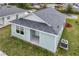 Back aerial view of home with light blue siding, gray roof, and green grass yard at 1282 Cottage Cir, Tavares, FL 32778