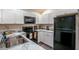 Modern kitchen featuring white cabinets, black appliances, and marble countertops at 1282 Cottage Cir, Tavares, FL 32778