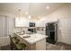 Well-lit kitchen with white cabinets, marble countertops, stainless steel appliances, and bar stool seating at 1282 Cottage Cir, Tavares, FL 32778