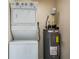A practical laundry area featuring a stacked washer and dryer unit, and water heater in a utility space at 1282 Cottage Cir, Tavares, FL 32778