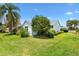 Well-maintained backyard featuring lush green grass and mature landscaping enhancing the property's curb appeal at 1306 Pedro Ct, The Villages, FL 32159
