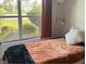 Cozy bedroom featuring a large window with a view of the lush greenery and landscaping at 1306 Pedro Ct, The Villages, FL 32159