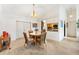 Dining area with view to the kitchen, features wood-look tile flooring and contemporary light fixture at 1306 Pedro Ct, The Villages, FL 32159