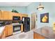 Traditional style kitchen with light wood cabinets, and modern black appliances at 1306 Pedro Ct, The Villages, FL 32159