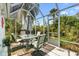Screened lanai with outdoor dining set and privacy plants, perfect for relaxing and entertaining at 1306 Pedro Ct, The Villages, FL 32159