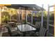 Screened lanai with outdoor dining set and mature landscaping, creating a tranquil outdoor space at 1306 Pedro Ct, The Villages, FL 32159