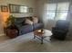 Comfortable living room with wood-look tile flooring, neutral colors, and natural light at 1306 Pedro Ct, The Villages, FL 32159