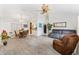 Bright, open-concept living room features vaulted ceilings, wood-look tile, and neutral paint at 1306 Pedro Ct, The Villages, FL 32159