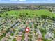 Beautiful aerial view of the neighborhood, lush golf course, and well-maintained homes, marked with locator pin at 1307 Galindo Pl, The Villages, FL 32159
