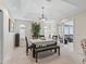 Bright dining room boasts tray ceiling, modern light fixture, and easy access to living area via french doors at 1307 Galindo Pl, The Villages, FL 32159