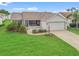 Charming single-story home with well-manicured lawn, attached two-car garage, and a screened in porch at 1307 Galindo Pl, The Villages, FL 32159