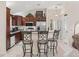 An open kitchen with stainless steel appliances, granite countertops, a breakfast bar, and dark wood cabinets at 1307 Galindo Pl, The Villages, FL 32159