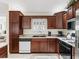 Well-lit kitchen with granite countertops, stainless steel appliances, and dark wood cabinets at 1307 Galindo Pl, The Villages, FL 32159