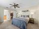 The main bedroom includes a ceiling fan, decorative wall art, and access to ensuite bathroom and closet at 1307 Galindo Pl, The Villages, FL 32159