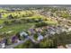 Community aerial view with well-maintained homes near lush green golf course and mature trees at 13190 Se 93Rd Cir, Summerfield, FL 34491