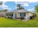 The back of the home has a patio with a grill and furniture, and a well-manicured lawn at 13190 Se 93Rd Cir, Summerfield, FL 34491