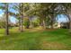 The green lawn is surrounded by trees and landscaping at 13190 Se 93Rd Cir, Summerfield, FL 34491