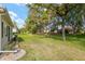 The backyard has a large area of green grass and is landscaped with rocks and bushes at 13190 Se 93Rd Cir, Summerfield, FL 34491