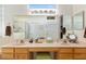 Bright bathroom features a double sink vanity, large mirror, and neutral decor at 13190 Se 93Rd Cir, Summerfield, FL 34491