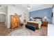 Cozy bedroom with blue accent wall, wood furniture, and decorative rug at 13190 Se 93Rd Cir, Summerfield, FL 34491