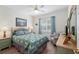 Comfortable bedroom with a ceiling fan, large window, and a striped armchair at 13190 Se 93Rd Cir, Summerfield, FL 34491
