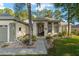 Inviting home exterior with a well-maintained lawn, a decorative palm tree, and a charming covered front porch entrance at 13190 Se 93Rd Cir, Summerfield, FL 34491